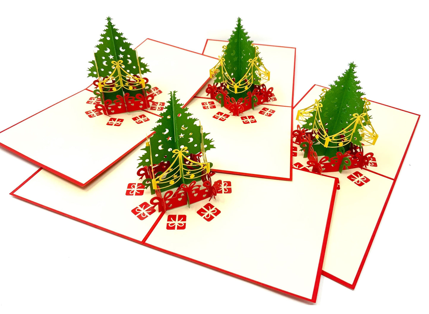 "A 4-pack of mini Christmas tree pop-up cards: A collection of four small three-dimensional cards, each featuring an intricately crafted pop-up of a Christmas tree, perfect for celebrating the holiday season in a compact size."